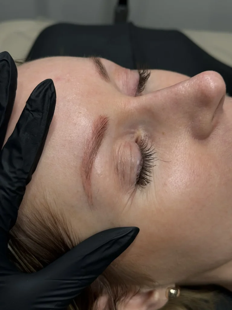 Arbeit mit Handschuhen im Augenbrauenbereich eines liegenden Modells.